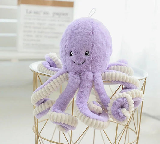 peluche pieuvre violette sur table blanche