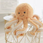 peluche pieuvre brun sur table blanche