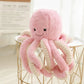 peluche pieuvre rose sur table blanche