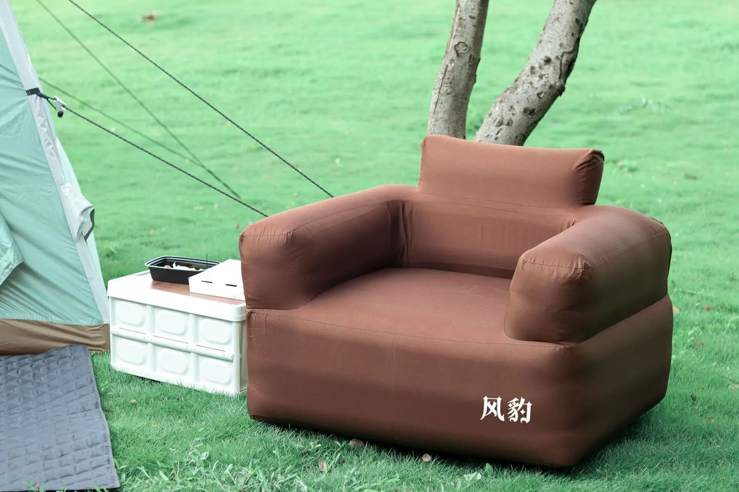 sofa gonflable hors de tente sur gazon arbre derriere